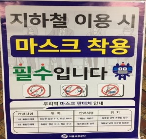 駅の構内に貼られたポスター「地下鉄の利用時、マスク着用は必須です」下の表にはマスクの販売所名と販売所の位置の情報が書かれています。