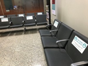 病院の待合室の椅子。ソーシャルディスタンスを保つため、座れないところにシールが貼ってあります。